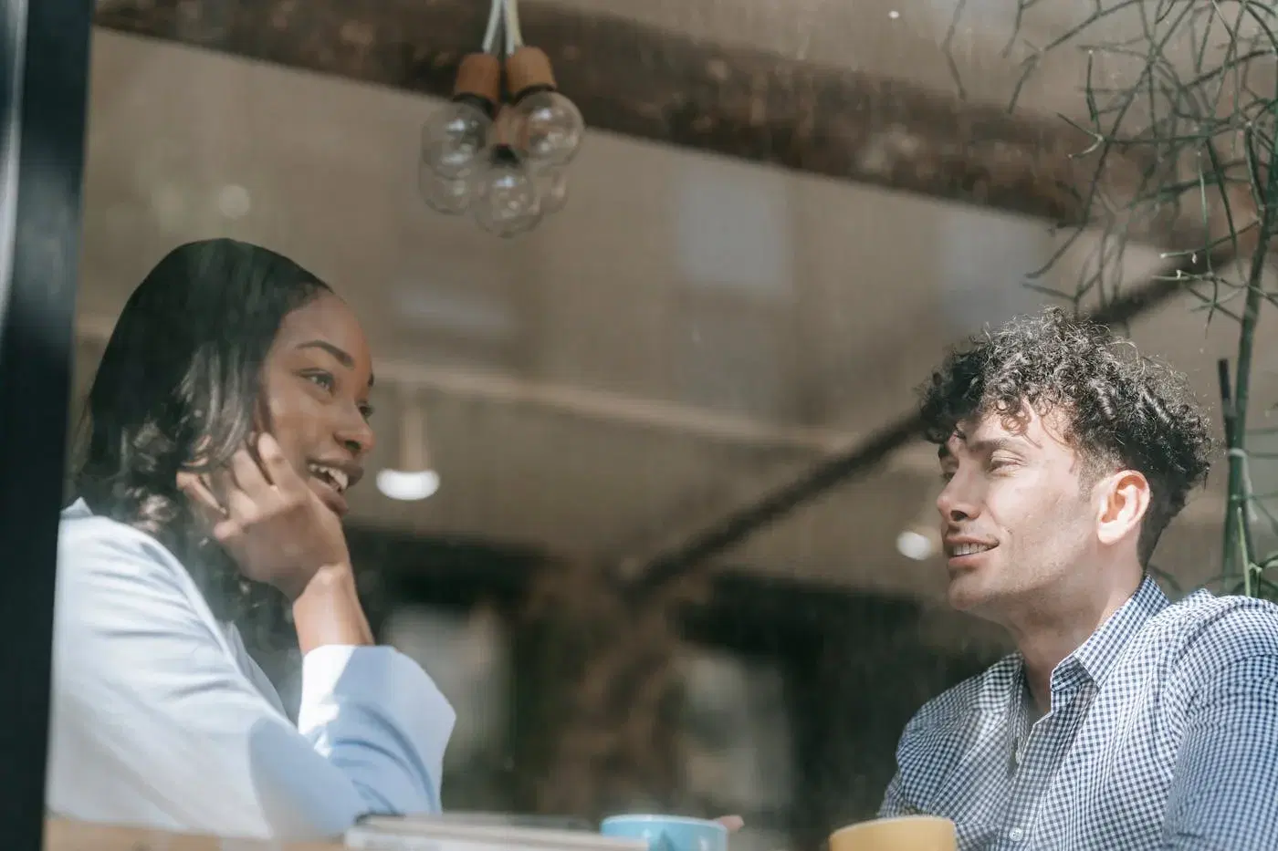 A man and woman in calm conversation near a window