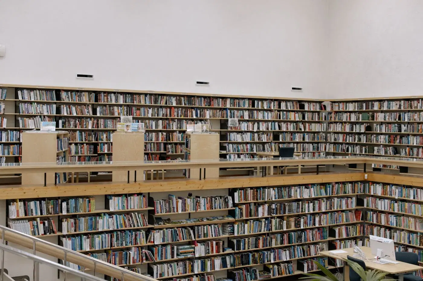 Rows of book-filled shelves running the length of a bright library